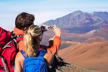 Happy couple taking photo of themselves with smart phone outdoors, Taking a "selfie"の写真素材