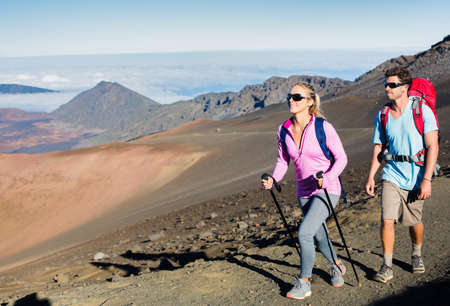 Man and woman hiking on beautiful mountain trail. Trekking and backpacking in the mountains. Healthy lifestyle outdoor adventure concept.の写真素材