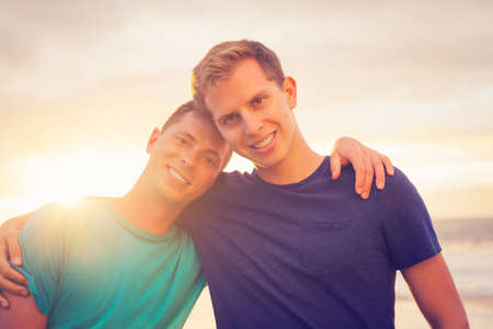 Gay couple on the beach at sunsetの写真素材