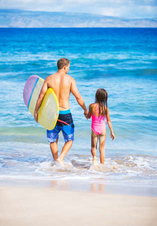 Father and Daughter on the Beach going Surfing Together in Hawaiiの写真素材