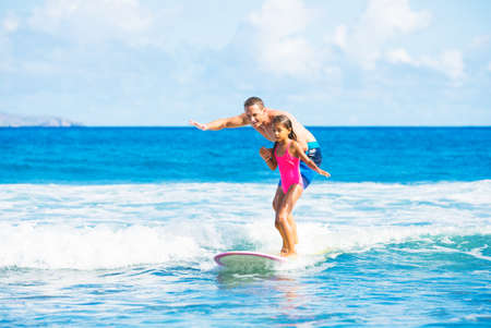 Father and Daughter Surfing Together Catching Wave, Summer Lifestyle Family Conceptの写真素材