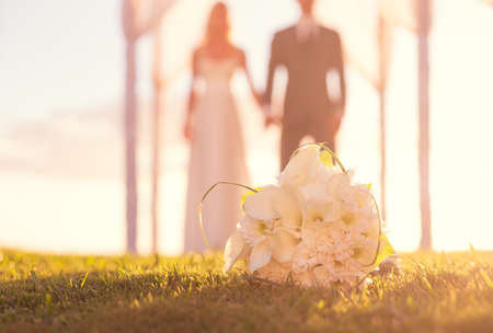 Close up of Wedding Bouquet. Focus on Flowers. Bride and Groom in Background.の写真素材