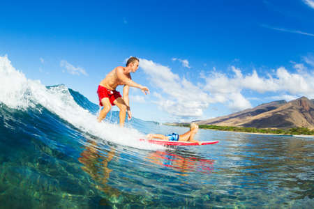 Father and Son Surfing Together. Riding Wave on Surfboard Tandem. Fatherhood, Family Fun Outdoor Lifestyle.の写真素材