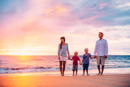 Happy Family of Four on the Beach at Sunsetの写真素材
