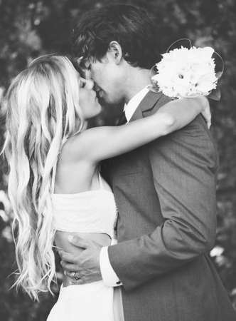 Wedding, Beautiful Romantic Bride and Groom Kissing and Embracing at Sunset. Black and White Image.の写真素材