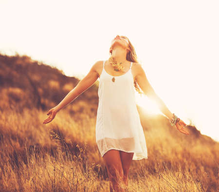 Happy Carefree Young Woman Outdoors. Fashion Lifestyle Portrait. Soft warm sunny colors.の写真素材