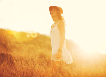 Happy Carefree Young Woman Outdoors. Fashion Lifestyle Portrait. Soft warm sunny colors.の写真素材