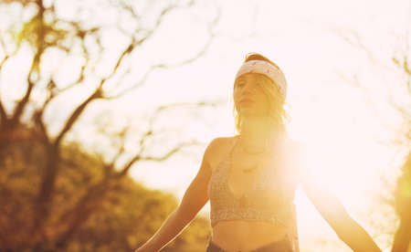 Fashion Lifestyle, Portrait of Beautiful Young Woman Backlit at Sunset Outdoors. Soft warm sunny colors.の写真素材