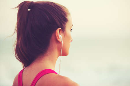 Active Sports Lifestyle with Modern Technology. Young fitness woman listening to music working out.の写真素材