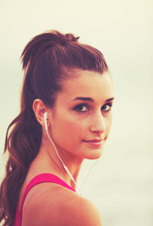 Active Sports Lifestyle with Modern Technology. Young fitness woman listening to musicの写真素材