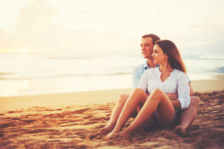Happy Romantic Couple Enjoying Beautiful Sunset at the Beachの写真素材