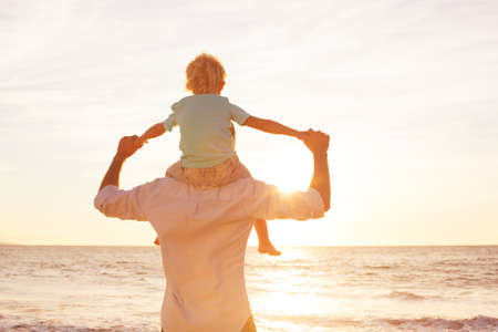 Father and Son Playing on the Beach at Sunsetの写真素材