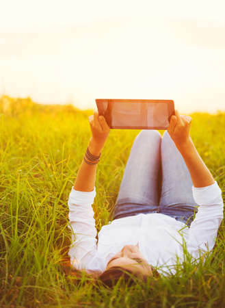 Happy Young Woman Using Tablet Outdoorsの写真素材