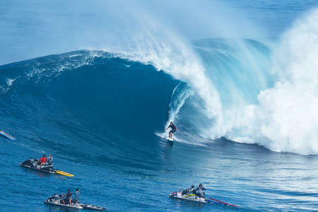 MAUI, HI - JANUARY 16 2016: Professional surfer Joao Marco Maffini rides a giant wave at the...