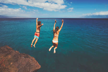 Cliff jumping into the ocean, summer fun adventure lifestyleの写真素材