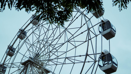 Ferris wheel on blue colorful sky background. Amusement park. Summer holidays and vacations.の写真素材