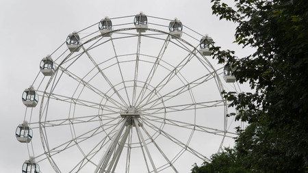 Ferris wheel on blue colorful sky background. Amusement park. Summer holidays and vacations.の写真素材