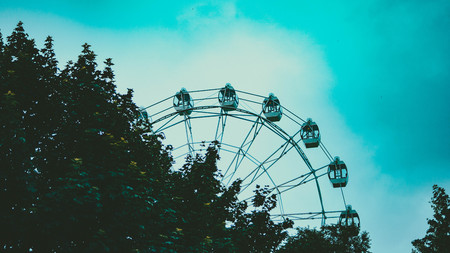 Ferris wheel on blue colorful sky background. Amusement park. Summer holidays and vacations.の写真素材
