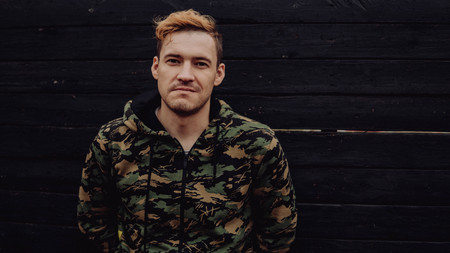 Guy camo, a man in a hoodie on a black wooden background. Soldiers at the wallの写真素材