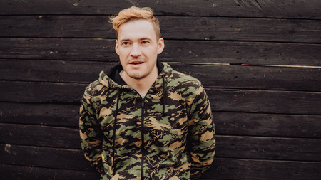 Guy camo, a man in a hoodie on a black wooden background. Soldiers at the wallの写真素材