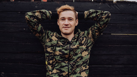 Guy camo, a man in a hoodie on a black wooden background. Soldiers at the wallの写真素材