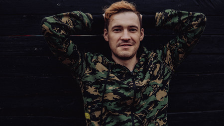 Guy camo, a man in a hoodie on a black wooden background. Soldiers at the wallの写真素材