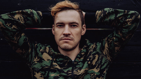 Guy camo, a man in a hoodie on a black wooden background. Soldiers at the wallの写真素材