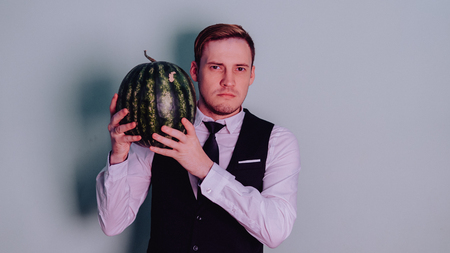 A man and a watermelon / Boy in classic suit with a watermelonの写真素材