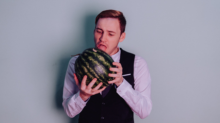 A man and a watermelon / Boy in classic suit with a watermelonの写真素材