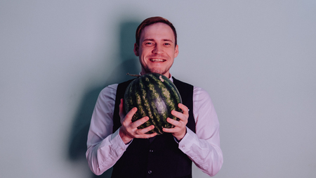 A man and a watermelon / Boy in classic suit with a watermelonの写真素材