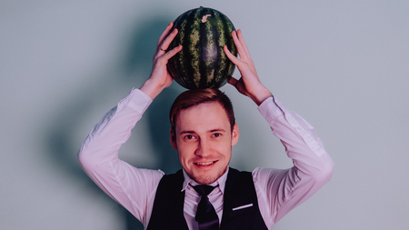 A man and a watermelon / Boy in classic suit with a watermelonの写真素材