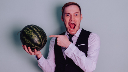 A man and a watermelon / Boy in classic suit with a watermelonの写真素材