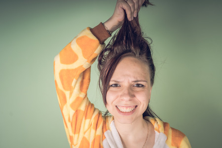 The girl has hair problems. Teenage woman having a problem with tangled tousled hair. Haircare problems concept. Bright splash of emotions on the faceの写真素材