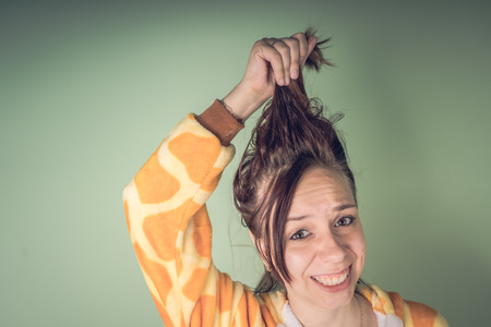 The girl has hair problems. Teenage woman having a problem with tangled tousled hair. Haircare problems concept. Bright splash of emotions on the faceの写真素材