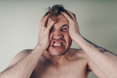 emotional portrait of a crazy guy in closeup. concept: the nervous breakdown, mental disease, headaches and migraineの写真素材