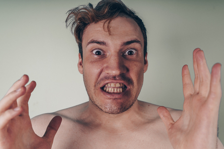 emotional portrait of a crazy guy in closeup. concept: the nervous breakdown, mental disease, headaches and migraineの写真素材