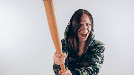 Girl with a bat. girl in the background. Body art. Sport and trainingの写真素材