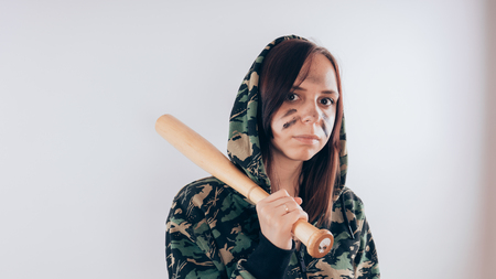 Girl with a bat. girl in the background. Body art. Sport and trainingの写真素材