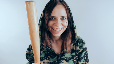 Girl with a bat. girl in the background. Body art. Sport and trainingの写真素材