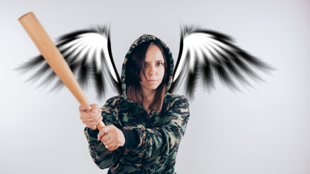 Girl with a bat. girl in the background. Body art. Sport and trainingの写真素材