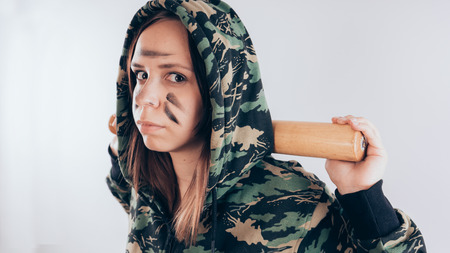 Girl with a bat. girl in the background. Body art. Sport and trainingの写真素材