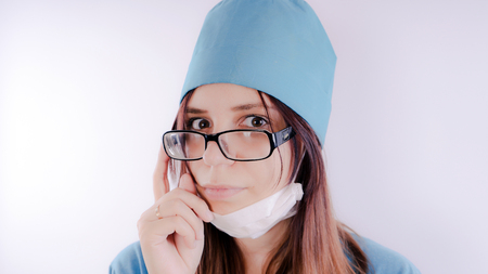 Portrait of a friendly smiling doctor woman or nurse in blue medical uniform, isolated on white background with copy space. Healthcare and medicine conceptの写真素材