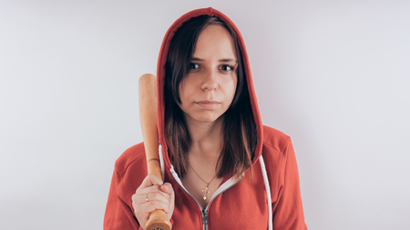 Girl with a bat. girl in the background. Body art. Sport and trainingの写真素材