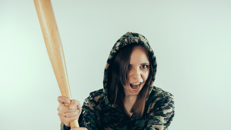 Girl with a bat. girl in the background. Body art. Sport and trainingの写真素材