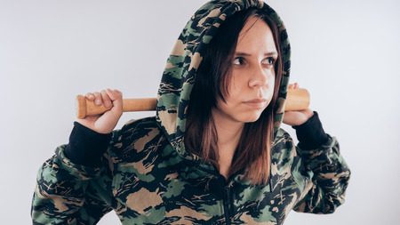 Girl with a bat. girl in the background. Body art. Sport and trainingの写真素材