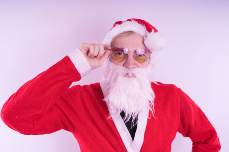 Emotional Santa Claus with glasses on blue background. Happy New Year and merry Christmas!の写真素材