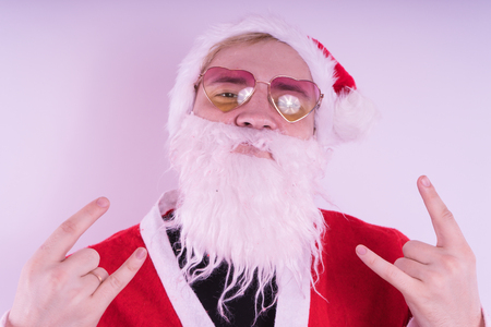 Emotional Santa Claus with glasses on blue background. Happy New Year and merry Christmas!の写真素材