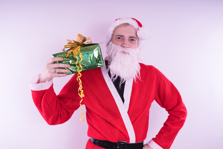 Portrait of thin Santa Claus with Christmas gifts. Happy Santa Claus holding gift boxes isolated on white background. Santa Claus carries gifts to children.の写真素材