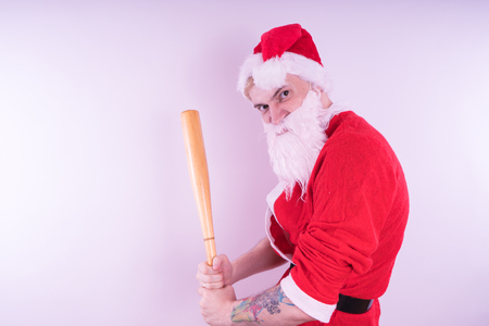 Emotional Santa Claus with a tattoo of a bat on a white background. The concept of an evil Santa Claus. Happy New Year and merry Christmas!の写真素材