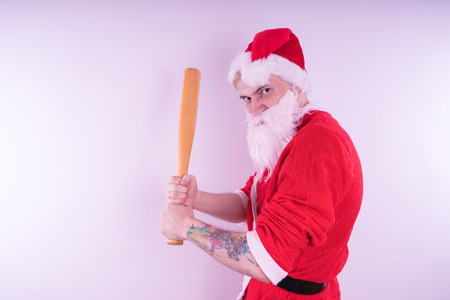 Emotional Santa Claus with a tattoo of a bat on a white background. The concept of an evil Santa Claus. Happy New Year and merry Christmas!の写真素材